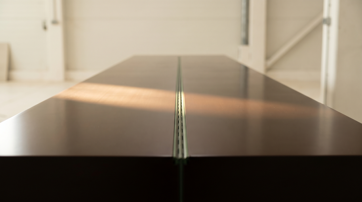 A lacquered surface with a structural seam visible only at an oblique angle — the polished exterior of a bundled IPO narrative and the joint underneath it.