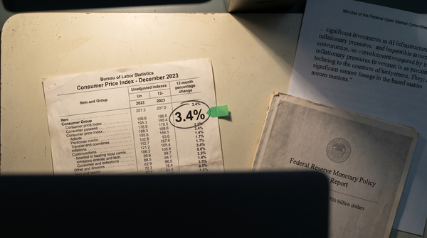 A CPI printout brightly lit on a desk next to FOMC minutes and Monetary Policy Report in partial shadow